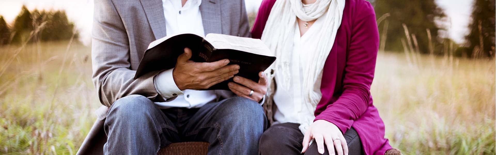 two people sitting together studying the bible.